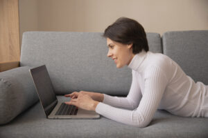 young woman using laptop on a couch
